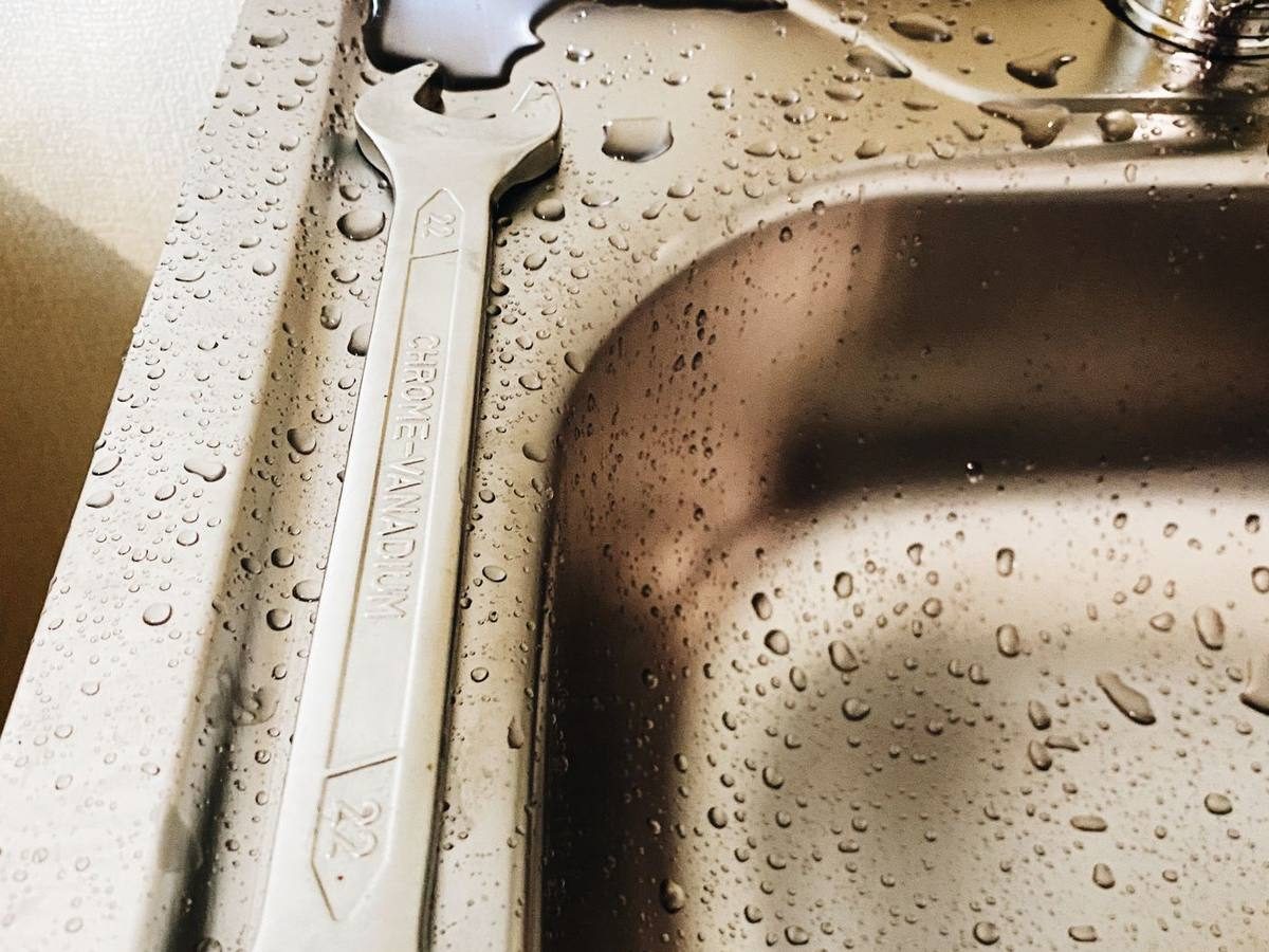 Wrench in a wet sink after a plumbing leak