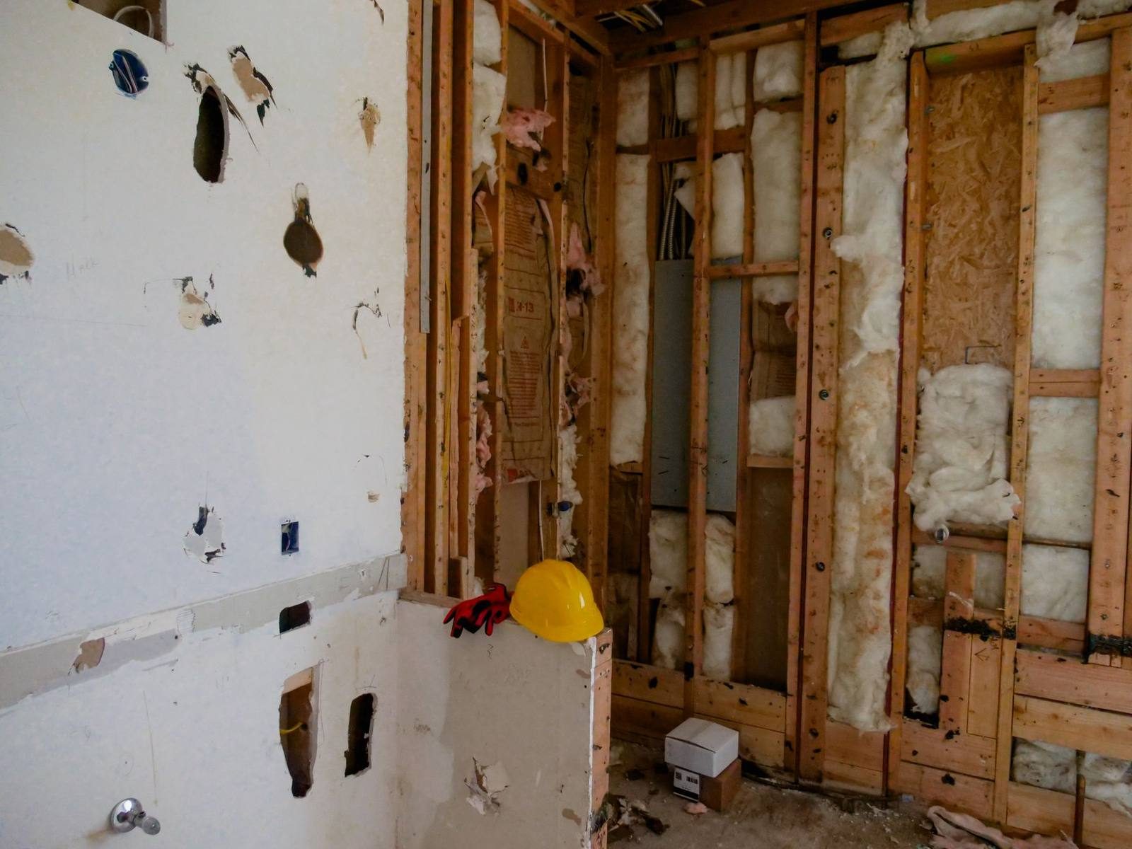 Wet drywall cut away to the studs and insulation during water damage cleanup